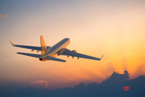 Passanger airplane flying above clouds in evening.